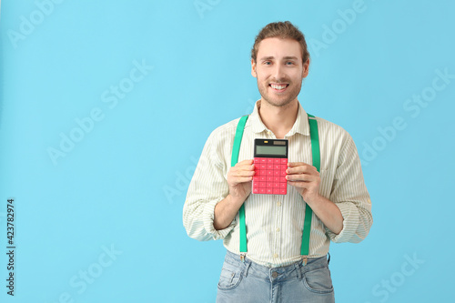 Young man with calculator o...