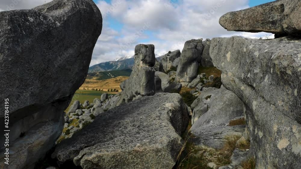 Close up shot of famous rock formation landmark at Castle Hill and beautiful rural landscape with mountains in backdrop. South Island,New Zealand. Close up shot of famous rock formation landmark at Castle Hill and beautiful rural landscape with mountains in backdrop. South Island,New Zealand.
