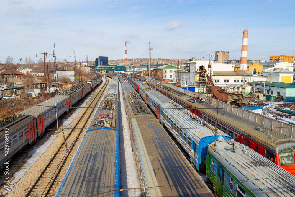 Fototapeta premium Variety of passenger trains standing at a dead end in a railway station. Top view. Krasnoyarsk railway station. Translation: Sorokino