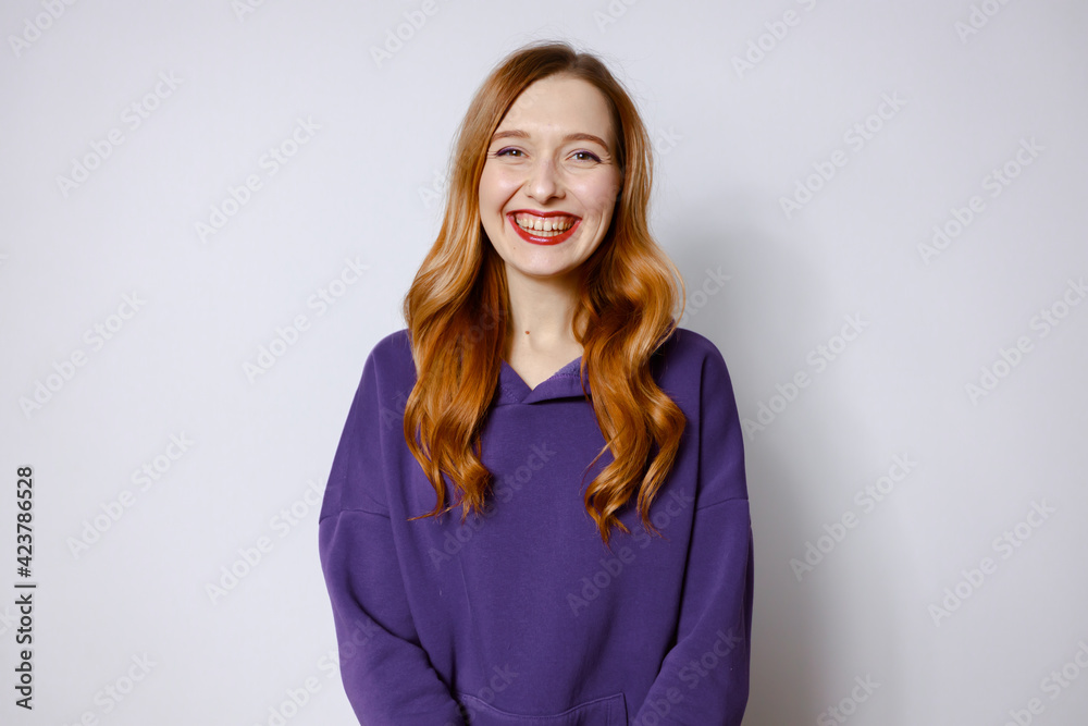 redhead women laughing in purple hoodies. Light background redhead women laughing in purple hoodies. Light background