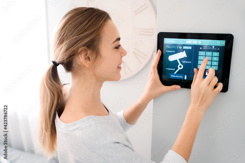 Woman using smart home security system control panel Woman using smart home security system control panel