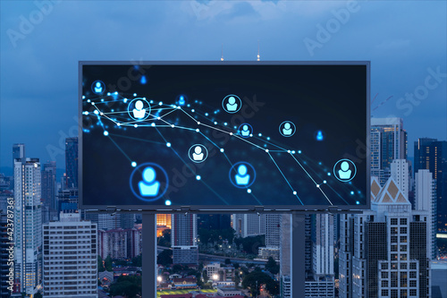 Glowing Social media icons on billboard over night panoramic city view of Kuala Lumpur, Malaysia, Asia. The concept of networking and establishing new connections between people and businesses in KL