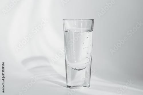Glass of clean mineral sparkling water on white background