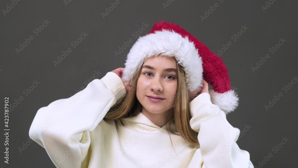 A girl puts on a Santa Claus Christmas hat. A girl puts on a Santa Claus Christmas hat.