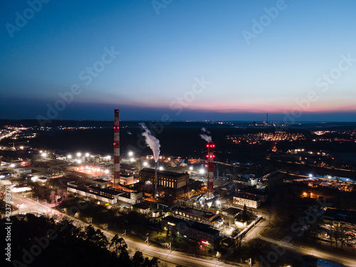 Thermal power station - industrial area at night with chimneys of power plant station with smoke in Vilnius, Lithuania