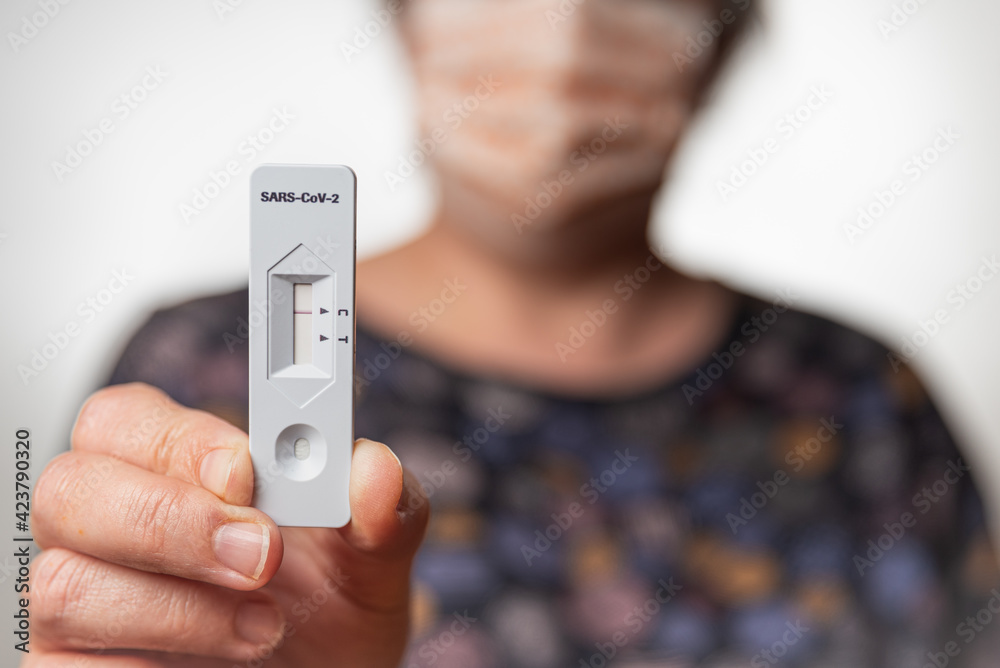 Negativer Corona-Schnelltest wird in Hand gehalten Negativer Corona-Schnelltest wird in Hand gehalten