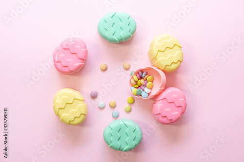 Minimalism concept of Easter candies on pink background. Flat lay. Space for text. 