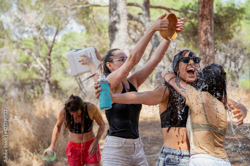 San martin de Valdeiglesias, Madrid, Spain. Group of women playing with water to cool off in summer near a fountain. photo