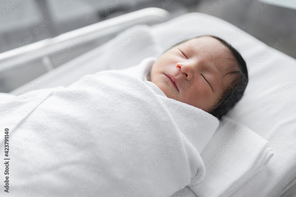 Newborn baby sleeping in blanket in delivery room.
Newborn baby sleeping in blanket in delivery room.