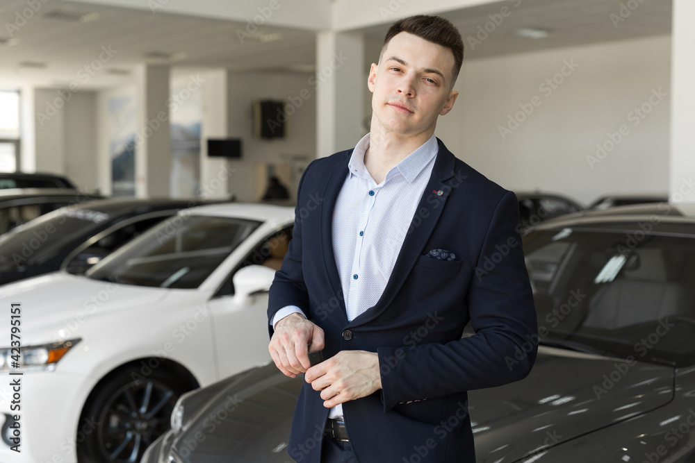 Handsome man choosing a car in a show room Handsome man choosing a car in a show room