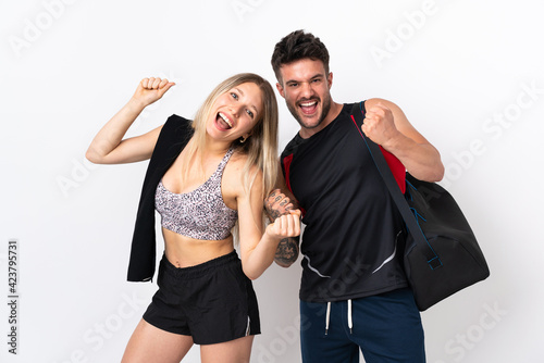 Young sport couple isolated on white background celebrating a victory