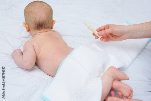 close-up - a baby gas passer in the hands of a mother against the background of a baby.Colic in a newborn and bloating. photo