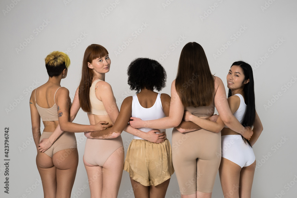 Back view of the group of five diverse women posing in studio