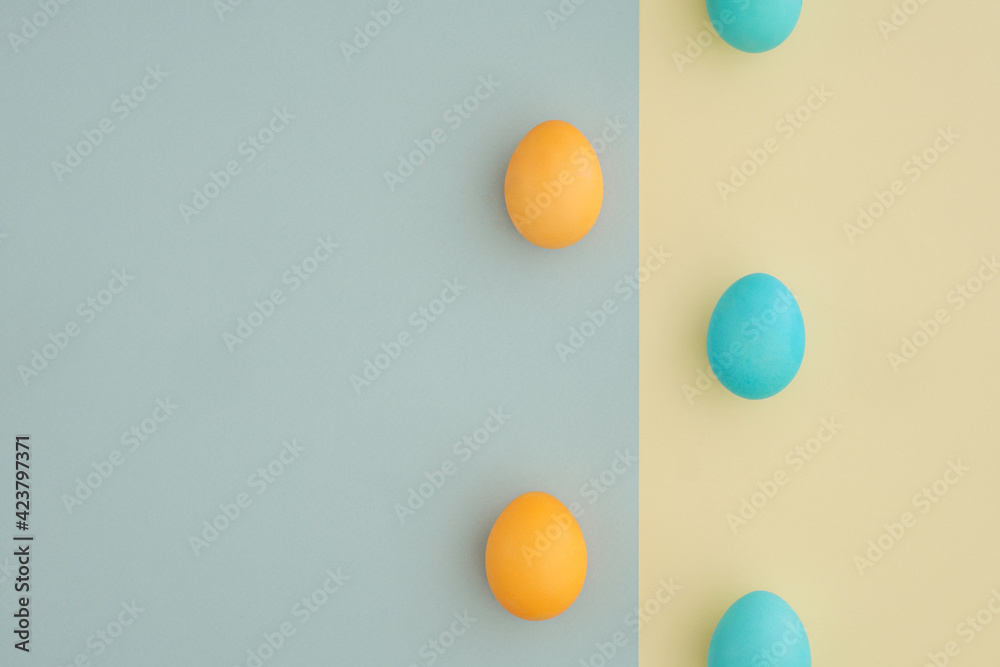 Creative Easter background with yellow and blue eggs on a two-color pastel background with space for text, top view, flat lay. Postcard, congratulations, minimalism, aesthetics Creative Easter background with yellow and blue eggs on a two-color pastel background with space for text, top view, flat lay. Postcard, congratulations, minimalism, aesthetics