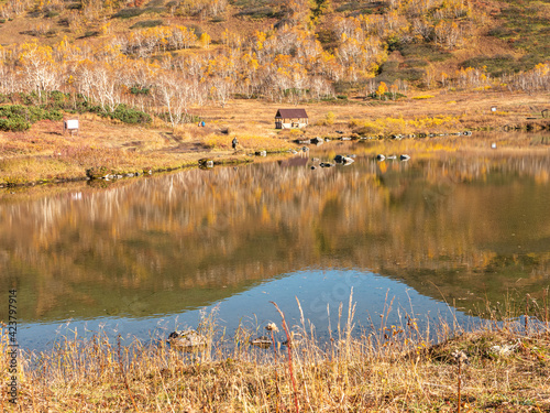 Beautiful autumn view of the lake and the Vachkazhets mountain range. Place for tourists to rest near the lake when visiting the mountains. Kamchatka Peninsula, Russia. photo