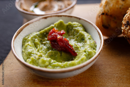 A bowl of green olive tapenade, close up