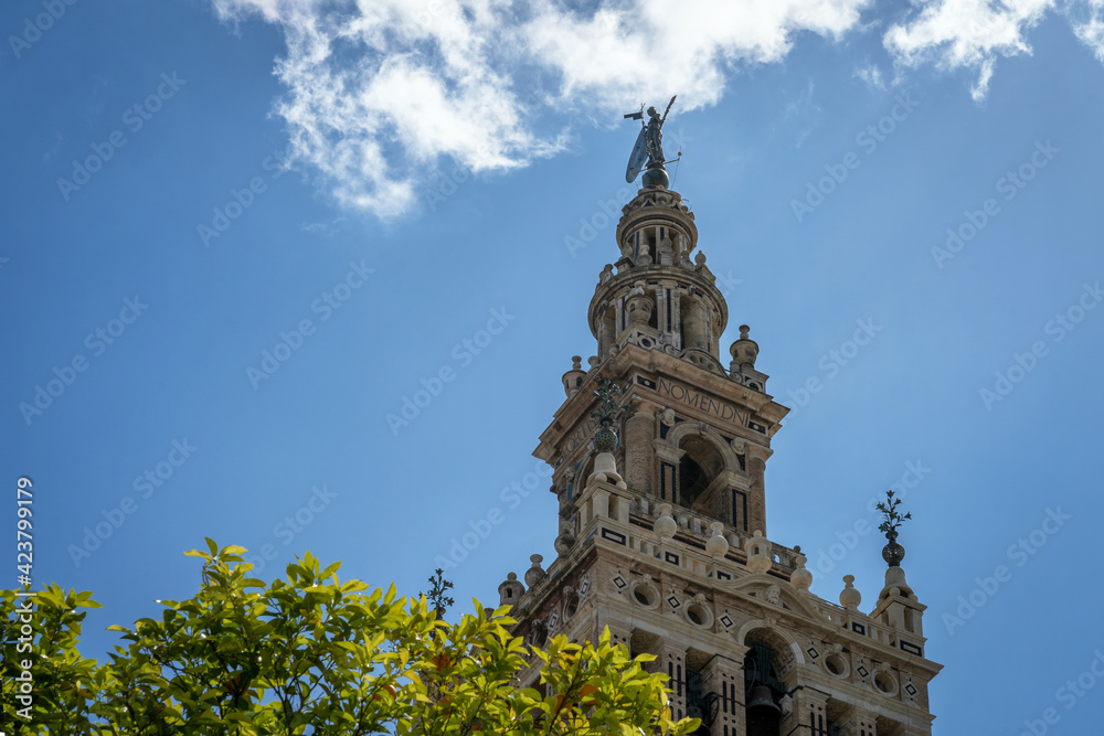 Obraz premium Seville Cathedral. La Giralda - bell tower with statue El Giraldillo on his top. Largest Gothic church in the world. Cathedral of Saint Mary of the See, Andalusia, Spain, Europe.