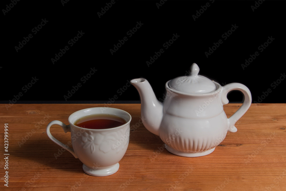 tea pot and cup of tea, isolated on black background tea pot and cup of tea, isolated on black background