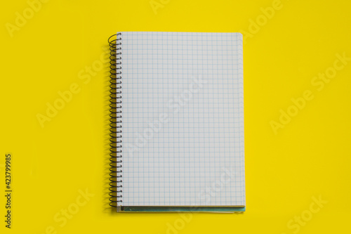 squared sheets spiral notebook, isolated on yellow background