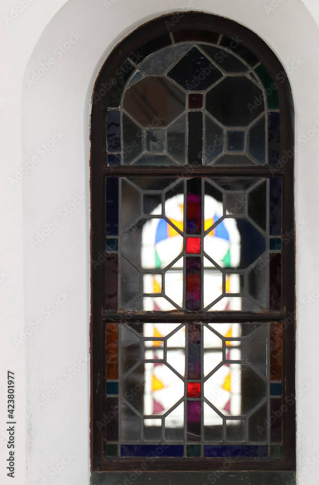 Gothic window on the church. Detail of glass filling. Colored stained glass.