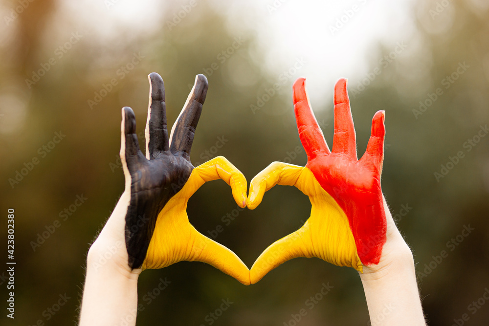 Obraz na plátně Kid hands painted in Belgium flag color show symbol of heart and love gesture on