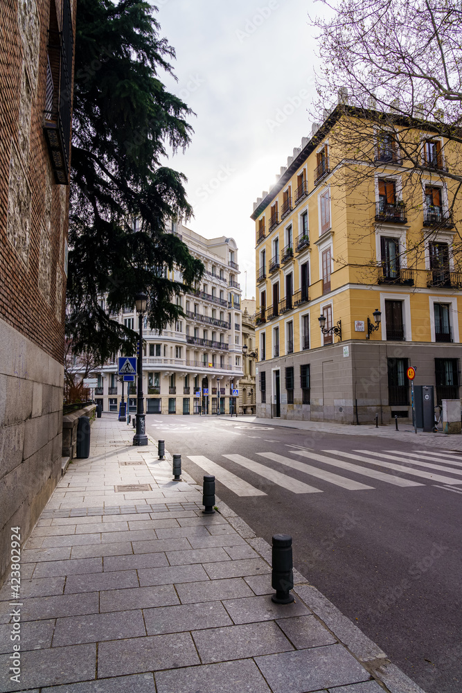 Madrid street with neoclassical buildings of different colors and typical balconies.