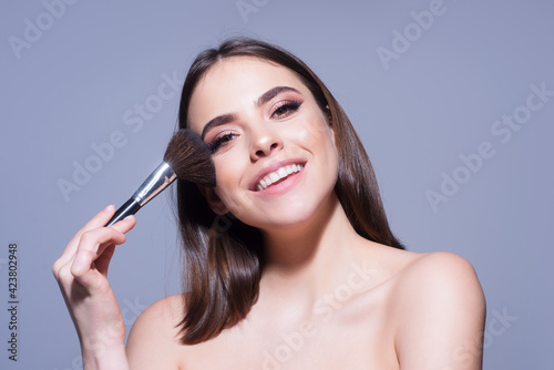 Attractive woman makeup blusher brush. Cosmetics product.