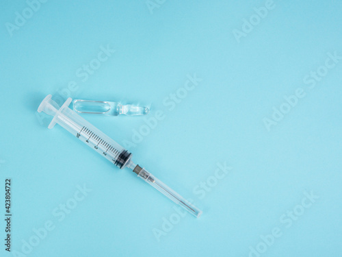 Syringe and ampoule on blue background