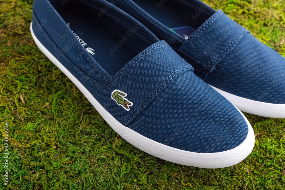 New Stylish Lacoste shoes. Blue comfortable shoes on the background of  green grass. Lacoste - French company founded in 1933 Stock Photo | Adobe  Stock