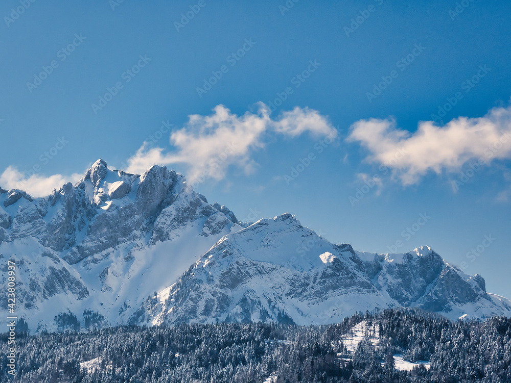 Side view of snow covered Mount Pilatus, blue sky with few clouds