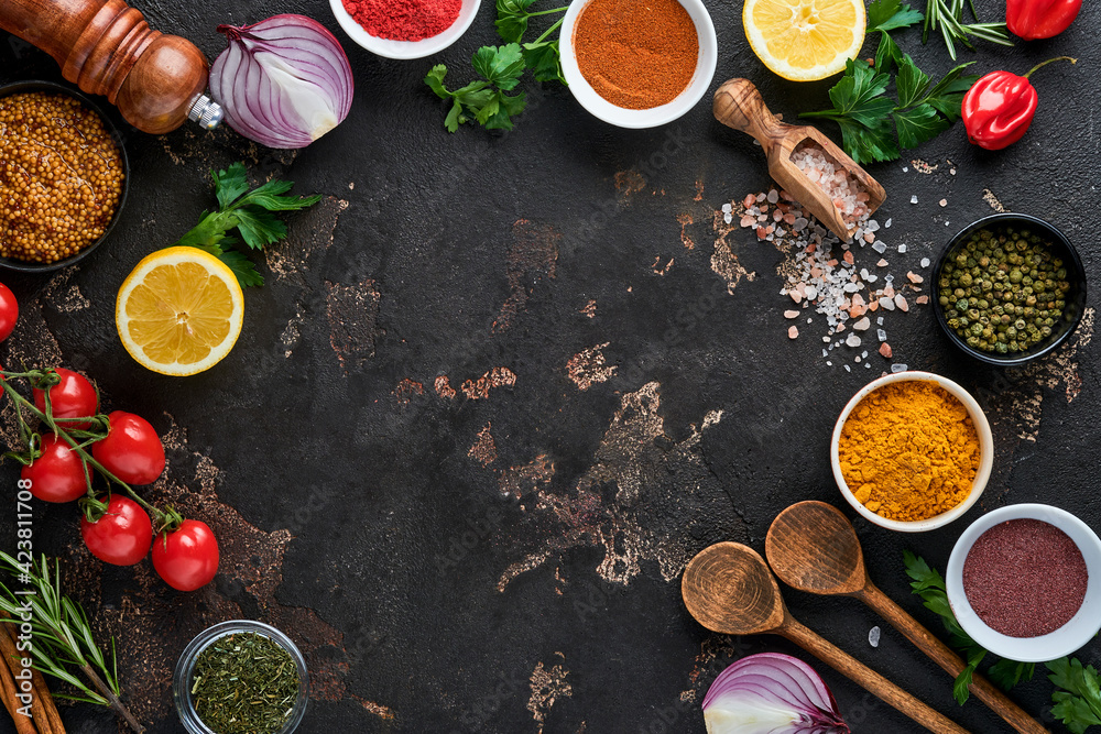 Set of Indian fragrant spices and herbs on a black stone background. Turmeric, dill, paprika, cinnamon, saffron, basil and rosemary in a spoon. Top view. Mock up. Set of Indian fragrant spices and herbs on a black stone background. Turmeric, dill, paprika, cinnamon, saffron, basil and rosemary in a spoon. Top view. Mock up.