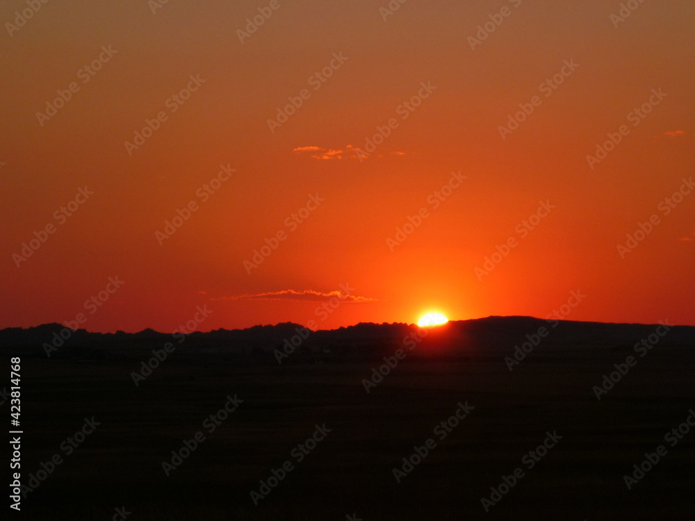 Scenic view of a sunset with bright red and orange glow at Badlands National Park in South Dakota Scenic view of a sunset with bright red and orange glow at Badlands National Park in South Dakota