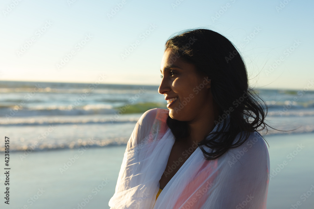 Mixed race patriotic woman on the beach wearing shawl looking toward sea Mixed race patriotic woman on the beach wearing shawl looking toward sea