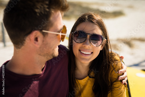 Happy caucasian couple by the sea embracing wearing sunglasses smiling © wavebreak3