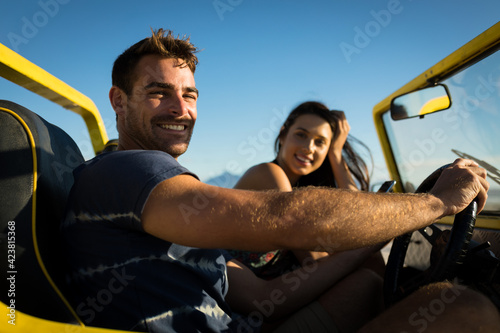 Happy caucasian couple sitting in beach buggy by the sea looking to camera © WavebreakMediaMicro