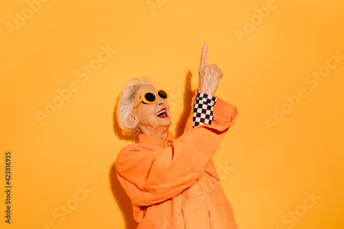 Woman smiling joyfully and pointing up with the finger photo