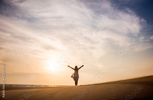 Freedom and happiness. Along young woman on sand enjoying sun, nature photo