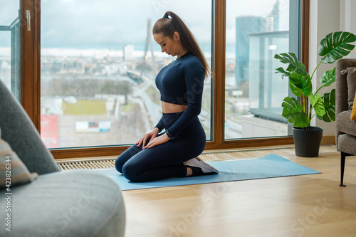 Free Download Young woman with dark hair in tracksuit sits in yoga pose - GFXLoad