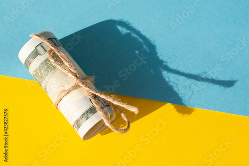 Twisted bundle 100 dollar bills on a yellow background. Business concept photo