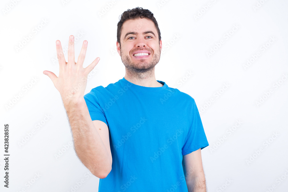 young handsome caucasian man wearing white t-shirt against white background smiling and looking friendly, showing number five or fifth with hand forward, counting down