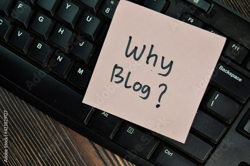 Why Blog? write on sticky notes isolated on Wooden Table.