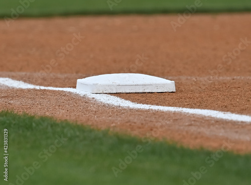 Third base bag on the line at a baseball field photo