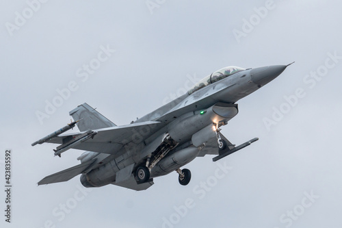 The F-16 Fighting Falcon take-off silhouetted against the gray sky