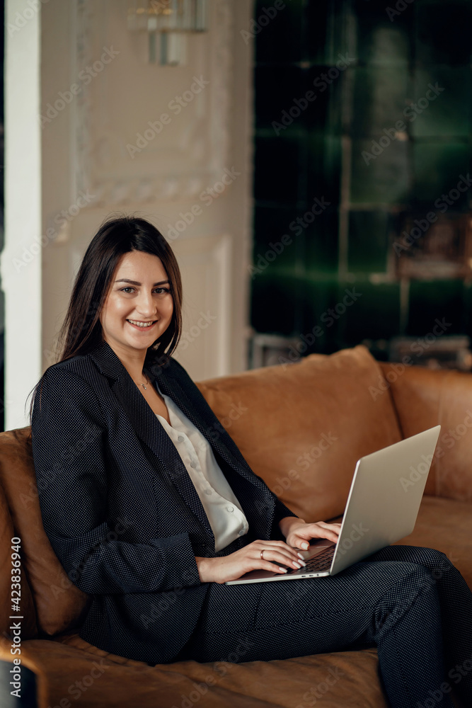 Works on a laptop computer. A confident financial manager. The lawyer is a business woman with a brunette European appearance. Located in a modern, stylish coworking office. Works on a laptop computer. A confident financial manager. The lawyer is a business woman with a brunette European appearance. Located in a modern, stylish coworking office.