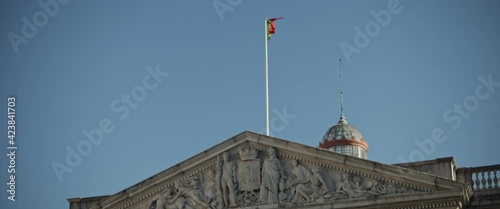 Portugal flag waving in the air on top of historical medieval architecture building. Slow motion.