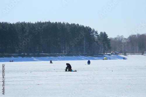 winter fishing on ice, natural background. fishermen fishing on frozen lake. Winter frosty morning fishing on river. Mozhayskoye Vodokhranilishche, Moscow Oblast, Russia Clear sunny day photo