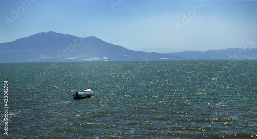 Boat in the water, scenery of mountains and sea. Feeling of grandeur, solitude. photo
