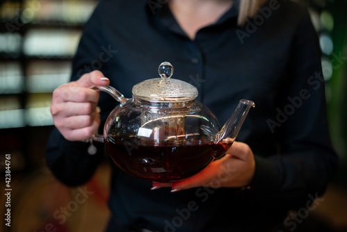 Woman holding teapot in the bar
