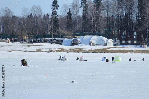 winter fishing on ice natural background. fishermen fishing. frozen lake. Winter frosty morning fishing on river. Mozhayskoye Vodokhranilishche Moscow Oblast Russia Clear sunny day Silhouettes people photo