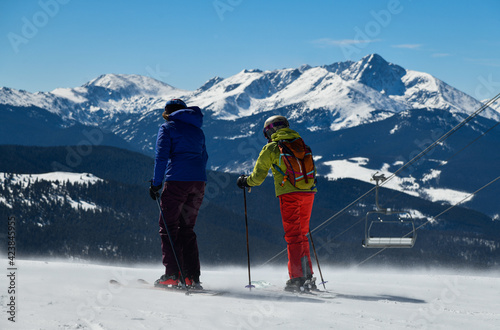Skiers overlooking to the panoramic view of Vail ski resort in winter time in the Colorado Rocky Mountains